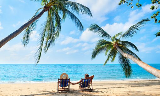 Couple relax on the beach enjoying beautiful sea on the tropical island. Summer beach vacation concept
